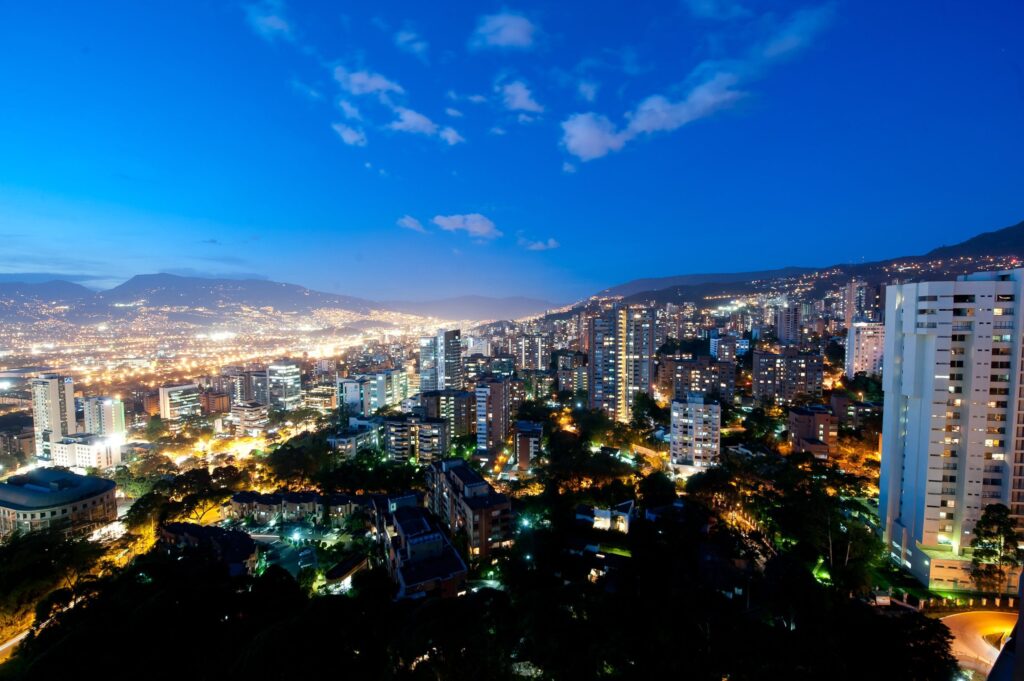 Medellín city skyline at night with glittering lights across the valley and modern buildings