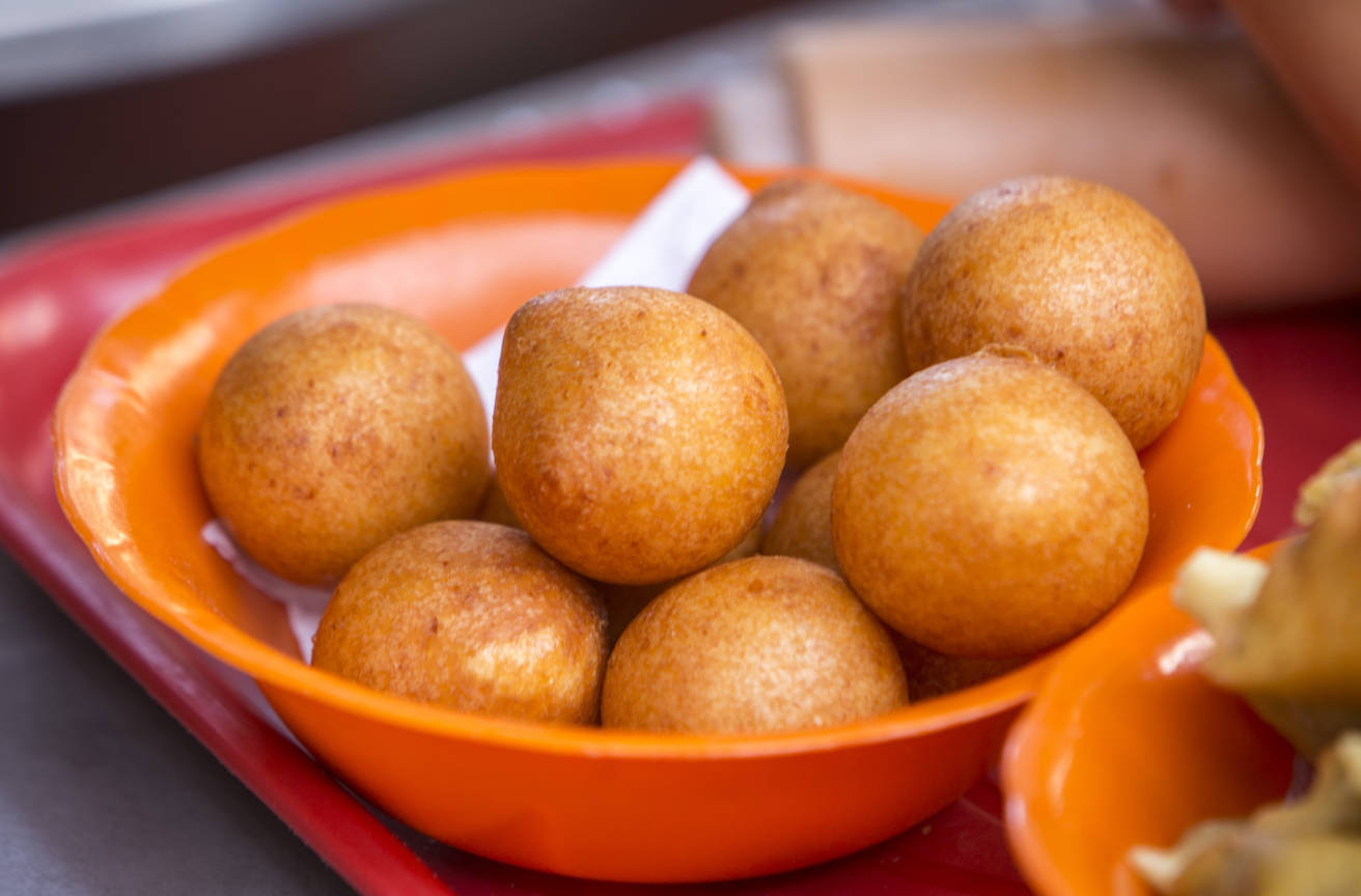 Bowl of freshly fried pandebono Colombian cheese bread balls served in an orange bowl